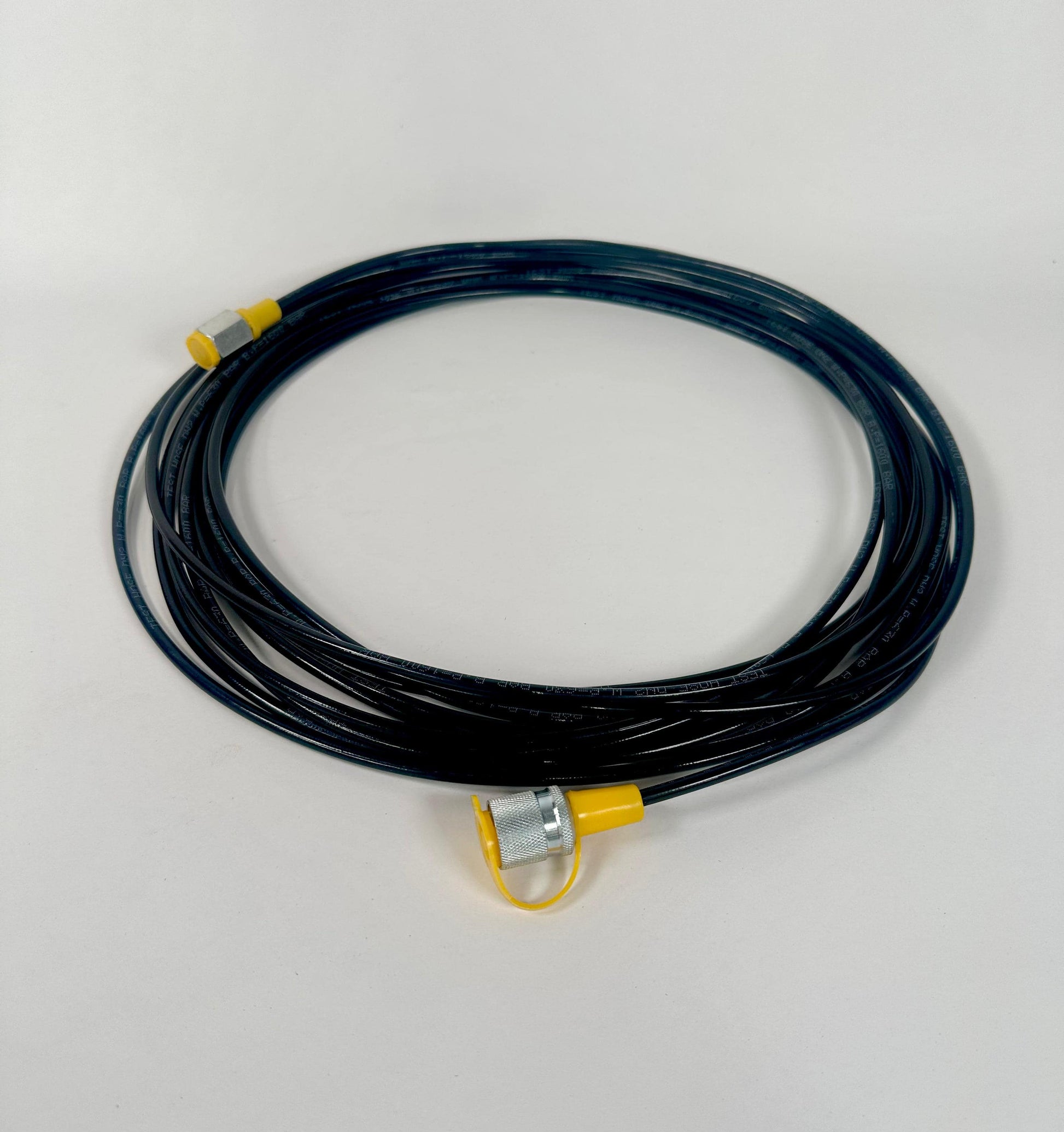 A 10-metre G1/4" to Stauff Style Test hose, coiled with yellow and silver connectors on each end, is shown on a plain white background.
