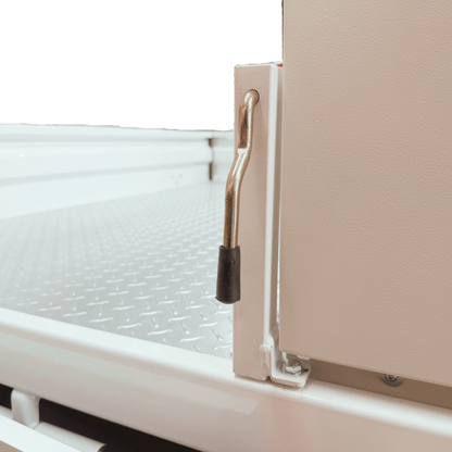 Close-up of a 30mm tray side shortening upright mounted to a white ute tray, showing the chrome S-shaped locking handle in the lowered position with a black rubber tip at the base. The existing black bracket from the tray is used for mounting.