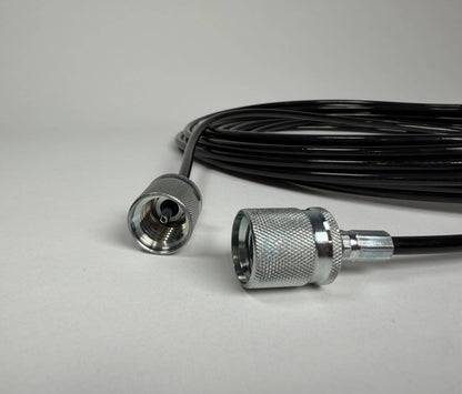 A close-up of a 5m Stauff to Stauff style test hose by Stauff, featuring silver metal connectors at both ends, placed on a plain light gray surface.
