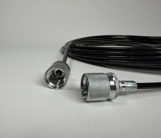 A close-up of a 5m Stauff to Stauff style test hose by Stauff, featuring silver metal connectors at both ends, placed on a plain light gray surface.